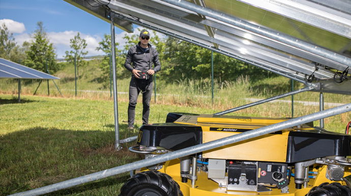 Spider Böschungsmäher mit patentiertem Dance-Step Antriebssystem unter Solarmodulen - Fernsteuerung ermöglicht 360° Lenksystem und Allradantrieb