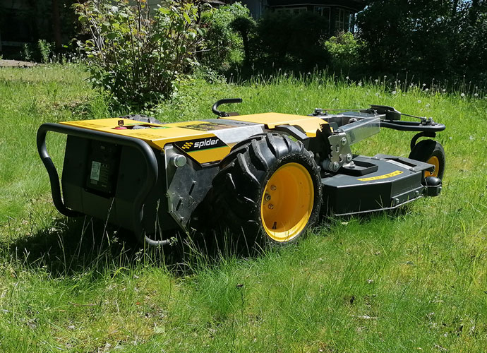 Spider eZERO elektrischer Böschungsmäher in Gelb-Schwarz auf Rasen - ferngesteuerter, emissionsfreier Großflächenmäher mit ultra-flacher Bauweise