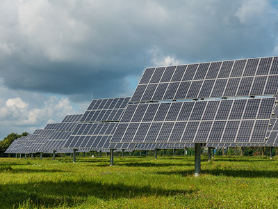 Solarpark mit Photovoltaik-Modulen und Grünfläche - Spider eZERO mit 47cm Bauhöhe mäht sicher unter und zwischen Solarmodulen ohne Beschädigungsrisiko