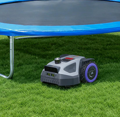 EIn Anthbot M9 Mähroboter mäht unter einem Trampolin
