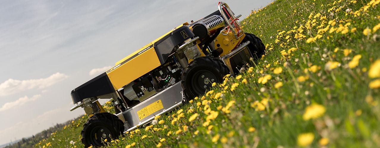 Auf diesem Bild ist der Spider 2SGS EFI Super Low zu sehen, wie er einen steilen, blumenreichen Hang hinauffährt.