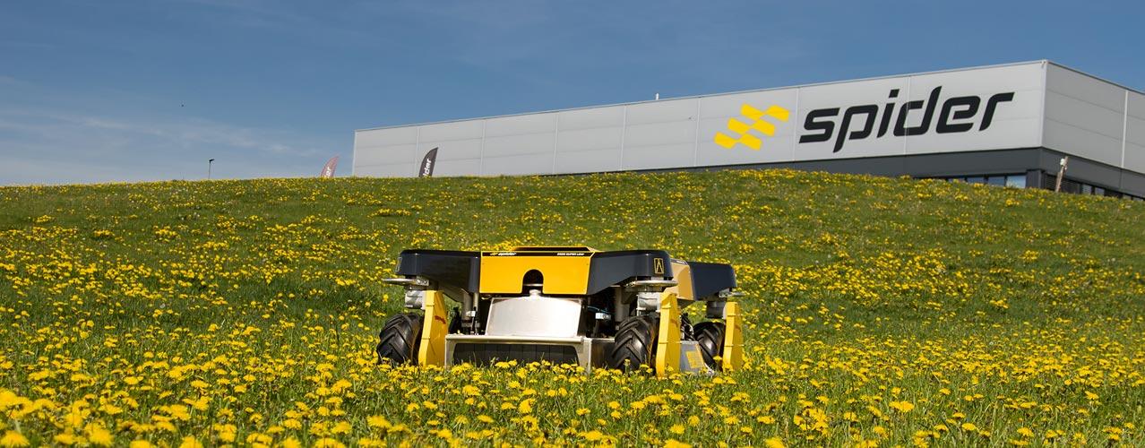 Auf diesem Bild ist der Spider 2SGS Super Low auf einer Blumenwiese vor dem Gebäude des Herstellers zu sehen.