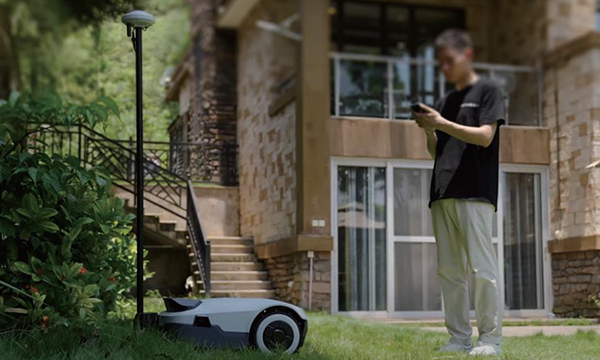 Auf diesem Bild sehen Sie einen Mann der seinem Mähroboter Anthbot installiert.